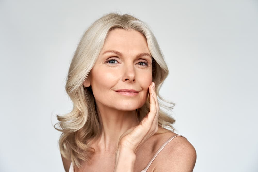 A confident woman with glowing, healthy skin after a summer facial treatment at The Beauty Spot in Wadebridge.